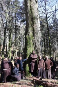 The Friars of the Sanctuary of La Verna pose in front of the tallest tree in Italy